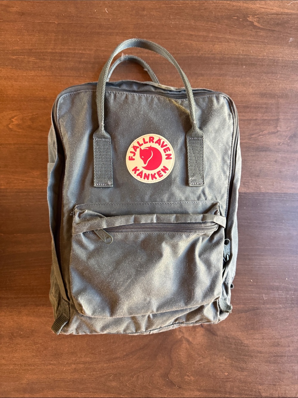 Fjallraven Kanken Backpack in a dark Olive Green with Red Logo